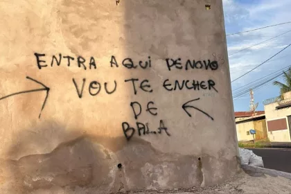 Texto escrito em um muro, entra aqui de novo que eu vou te encher de bala