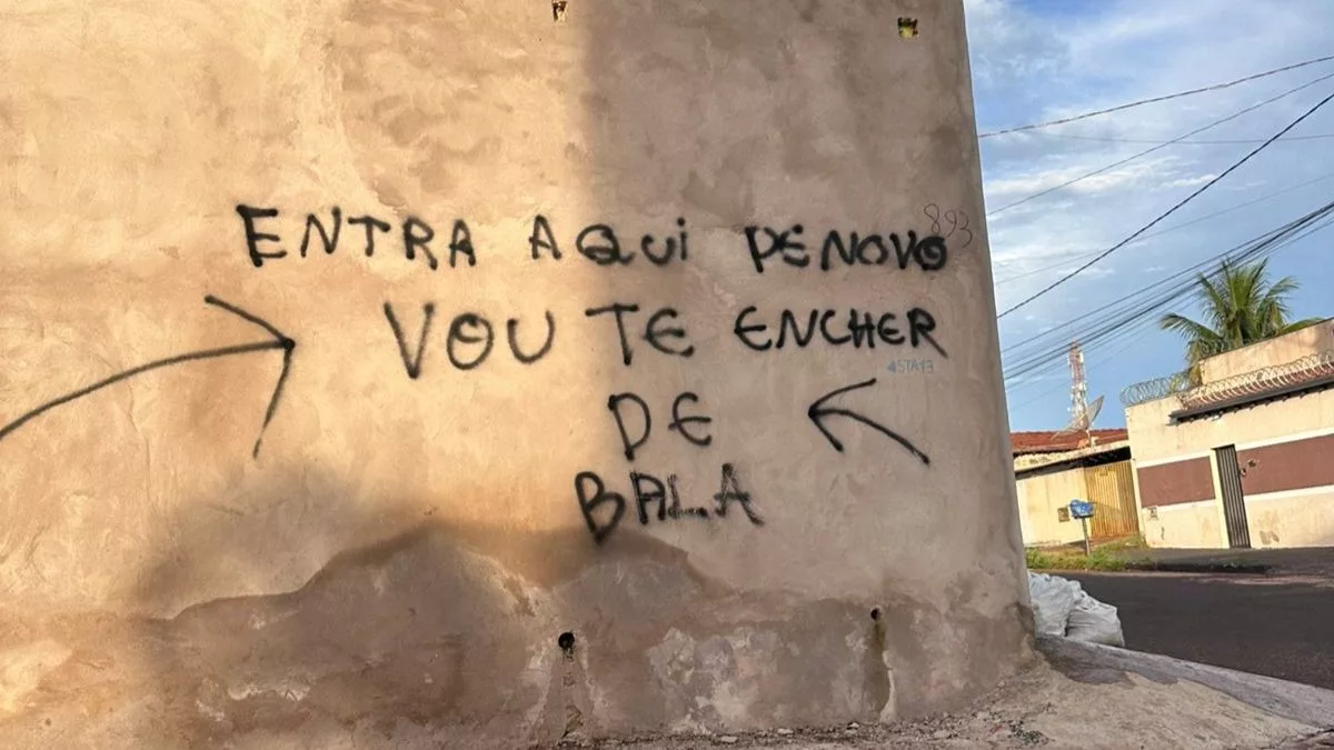 Texto escrito em um muro, entra aqui de novo que eu vou te encher de bala